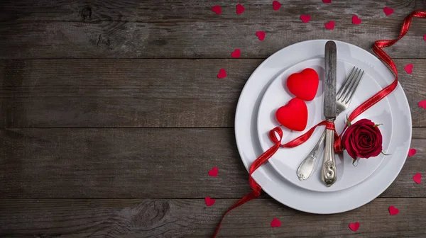 Conceito de jantar do dia dos namorados, prato branco plano, garfo, faca e dois corações vermelhos — Fotografia de Stock