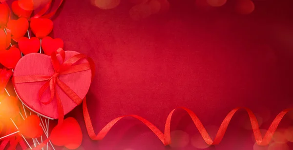 กล่องของขวัญบนผ้าสีแดง หัวใจสีแดง — ภาพถ่ายสต็อก