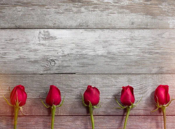 Cinque rose rosse sul vecchio tavolo — Foto Stock