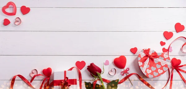 Cadeaudoosjes en roos op witte houten tafel — Stockfoto