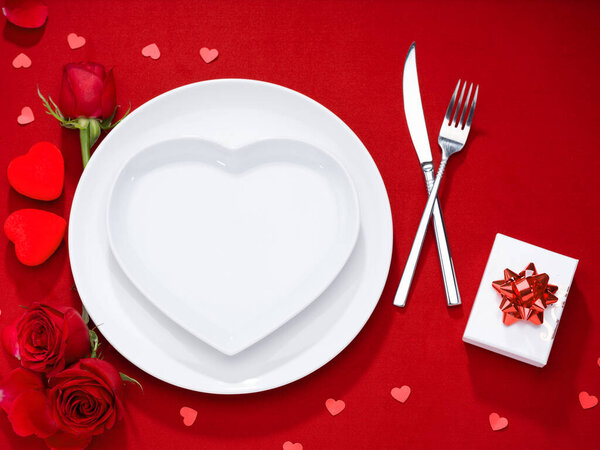 Тарелка, вилка, нож и подарочная коробка с розами на бархатной ткани
