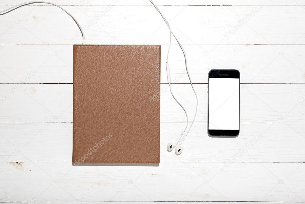 top view of earphone with notebook and phone