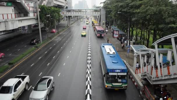 Bangkok, Tayland - Ocak 10,2017: bir otobüs otobüs durağı için bekleyen insanlar. BTS gökyüzü tren istasyonunun yakınında — Stok video