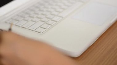 Bir kadın beyaz bir dizüstü kulaklık ses çıkışı bağlantısı