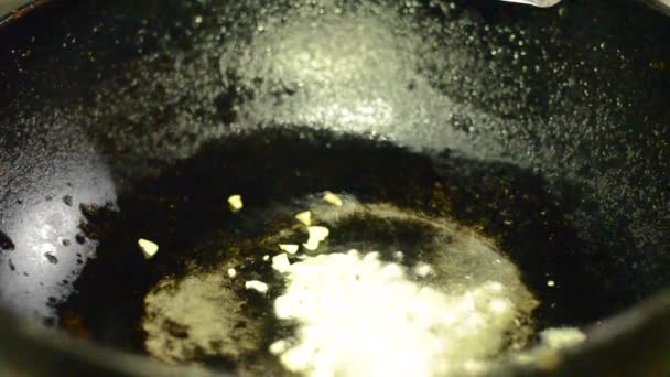 Чеснок поджаривают на сковороде. — стоковое видео