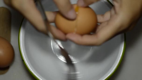 Hands cracking an egg into a bowl — Stock Video