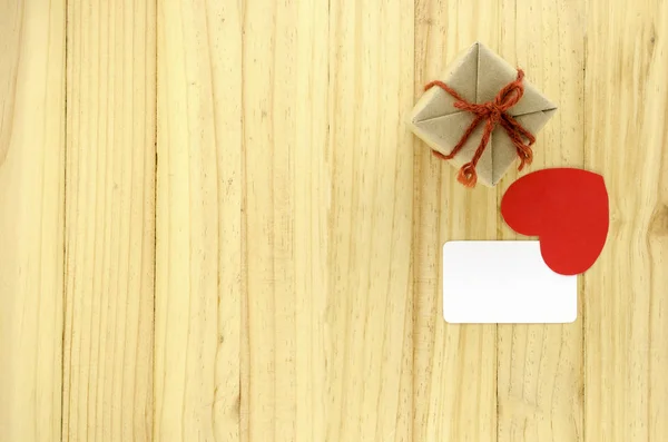 लकड़ी पृष्ठभूमि पर दिल के साथ शिल्प उपहार बॉक्स का शीर्ष दृश्य — स्टॉक फ़ोटो, इमेज