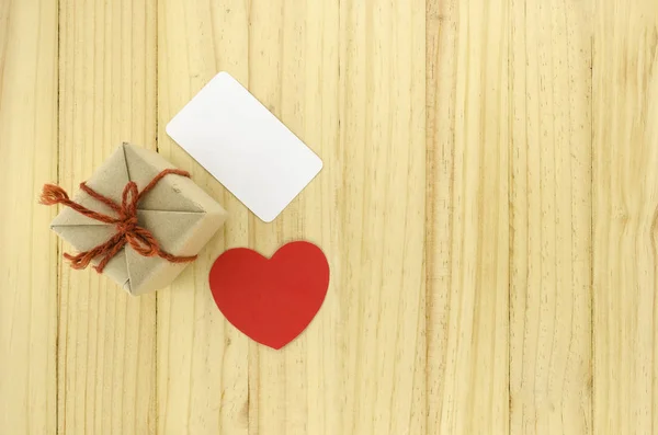 Draufsicht auf Handwerk-Geschenkbox mit Herz auf Holz-Hintergrund — Stockfoto