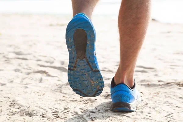 Healthy trail running on the beach, footprint close-up
