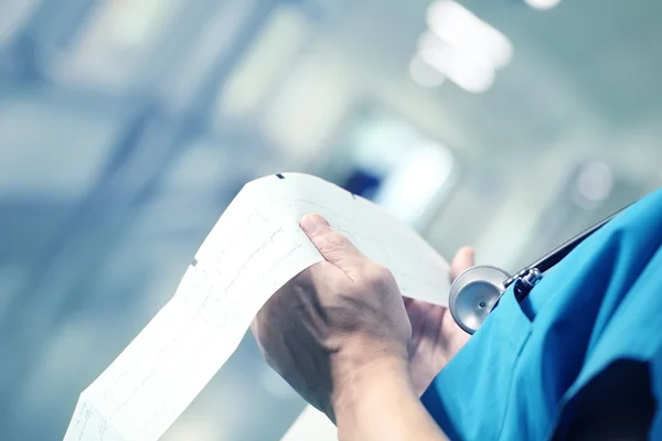 Doctor examining ECG in the hospital hallway — Stock Photo, Image