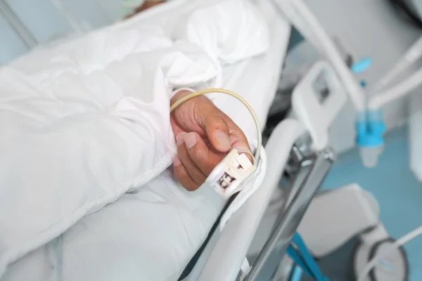 Рука пожилого пациента с датчиком пульса — стоковое фото