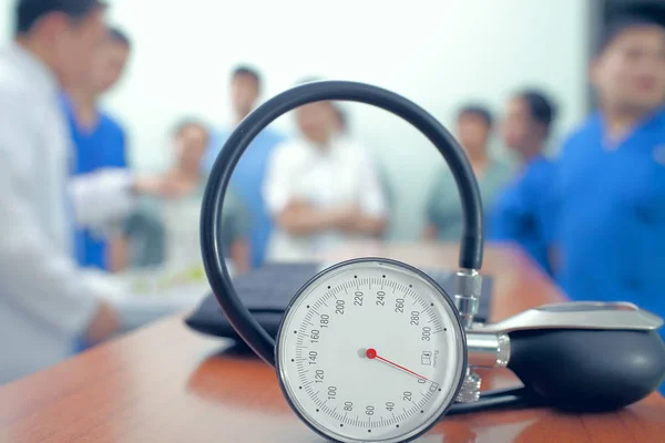Manometer at the table on the background of group of doctors — Stock Photo, Image