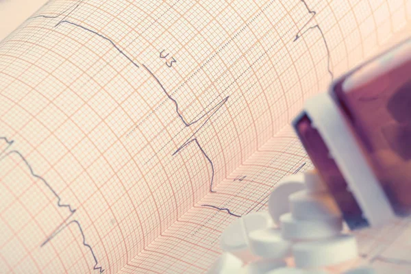 Pastillas en el papel ECG, concepto de enfermedades del corazón y los vasos sanguíneos — Foto de Stock