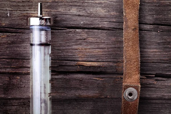 Glass syringe and a fragment of harness — Stock Photo, Image