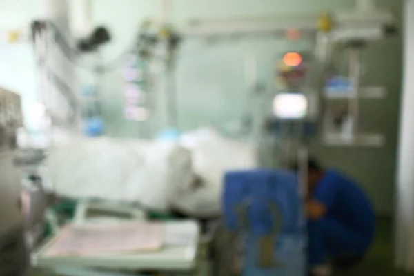 Hospital ward with sitting doctor and patient in bed, unfocused