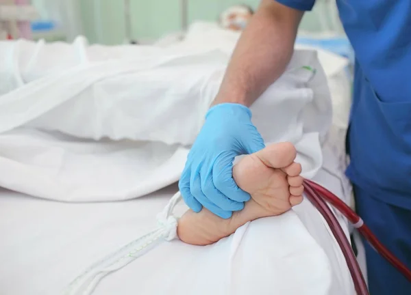 Arzt untersucht durch Berühren des Fußes des Patienten — Stockfoto
