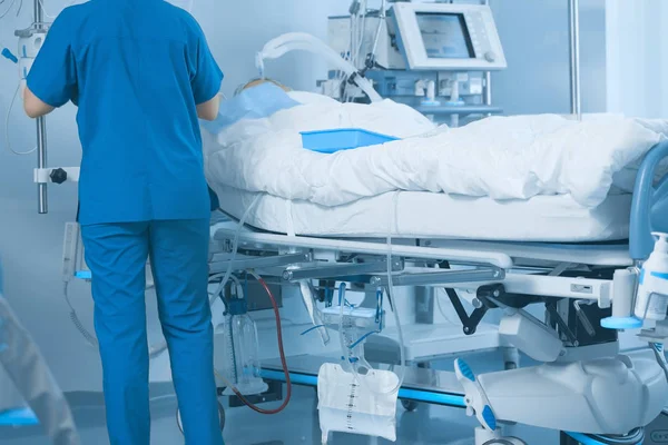 Medical hospital ward with a working nurse and patient on the be — Stock Photo, Image