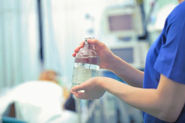 Klarsichtflasche in den Händen einer Krankenschwester vor dem Hintergrund — Stockfoto