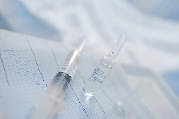 Medical ampoule and syringe on the ECG record — Stock Photo, Image