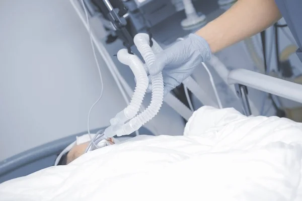 Médico da unidade de terapia intensiva controla a respiração do — Fotografia de Stock