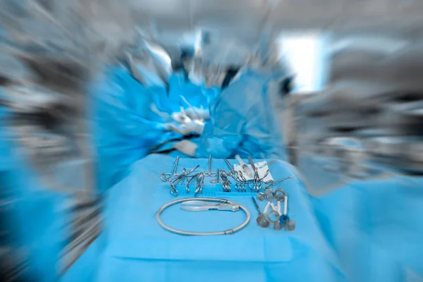 Narzędzia chirurgiczne w sali operacyjnej z niewyraźne sylwetki — Zdjęcie stockowe