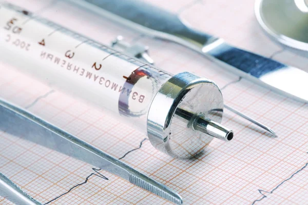 Instrumentos médicos obsoletos que yacen en el papel del ECG — Foto de Stock