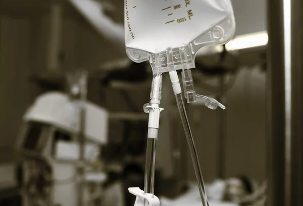 Medical drip bag on the background of patient bed surrounded by — Stock Photo, Image