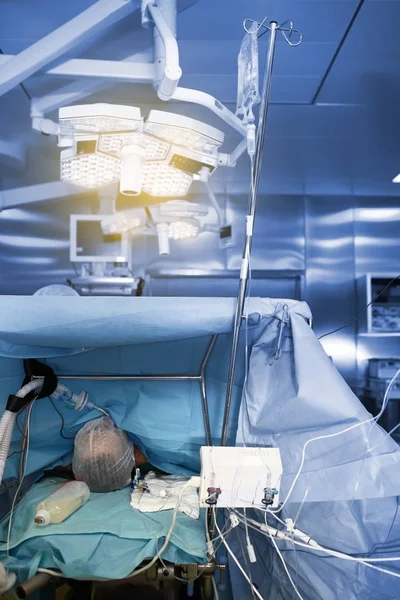 Sleeping patient on the operating table in the advanced surgery — Stock Photo, Image