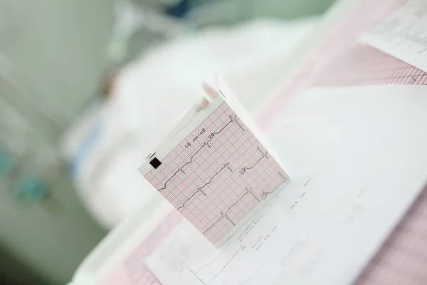 Desktop with medical papers on the background of patient lying i — Stock Photo, Image