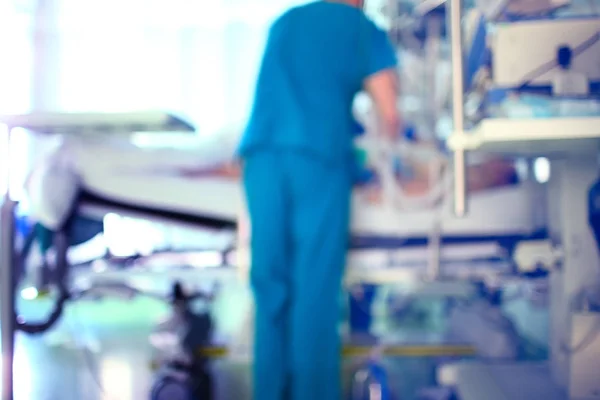 Silueta pracovní lékař u lůžka pacienta proti th — Stock fotografie