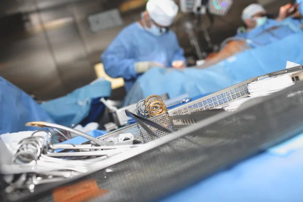 Herramientas quirúrgicas estériles en el plato en el fondo de trabajo —  Fotos de Stock