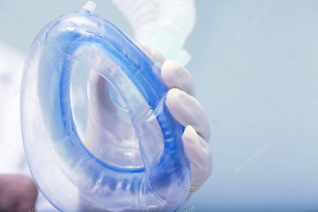 Doctor holds air breathing device on the patients face during pr