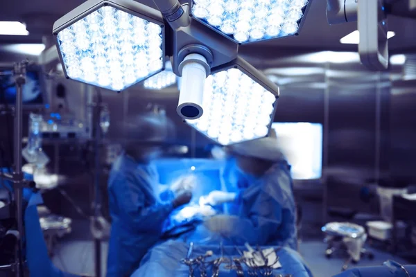 Löpande arbetet med kirurgen team i avancerade operationssalen — Stockfoto