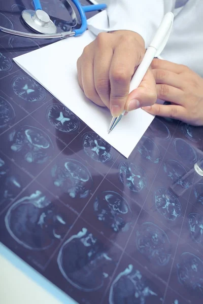 Médecin femme interprétant le film CT d'une patiente au bureau — Photo