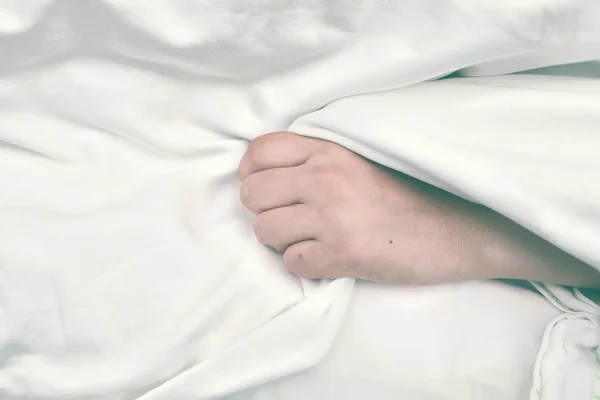 Тяжело больной пациент зажимает простыню в руке — стоковое фото