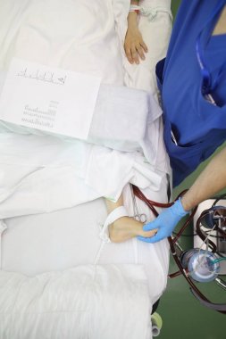Erkek Doktor hastanın ayak hemodilysis p sırasında palpates.