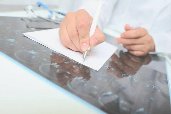 Femme médecin décrit l'image de balayage à la table — Photo