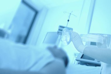 Kadın hemşire oksijen solunum maskesi ile pati için verir.