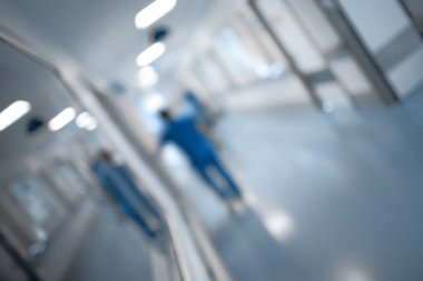 Sağlık personeli, odaklanmamış adam yürüme ile hastane koridoru