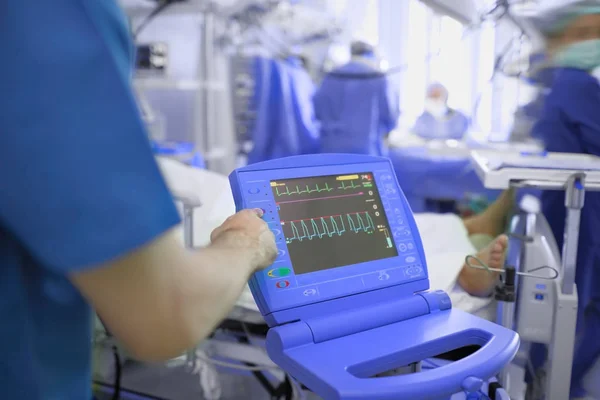 Medical doctor adjusting ECG monitor of comatose patient in the — Stock Photo, Image