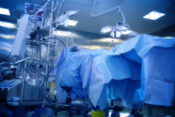 Sala de operaciones borrosa con mesa cubierta y equipo, desenfocado — Foto de Stock