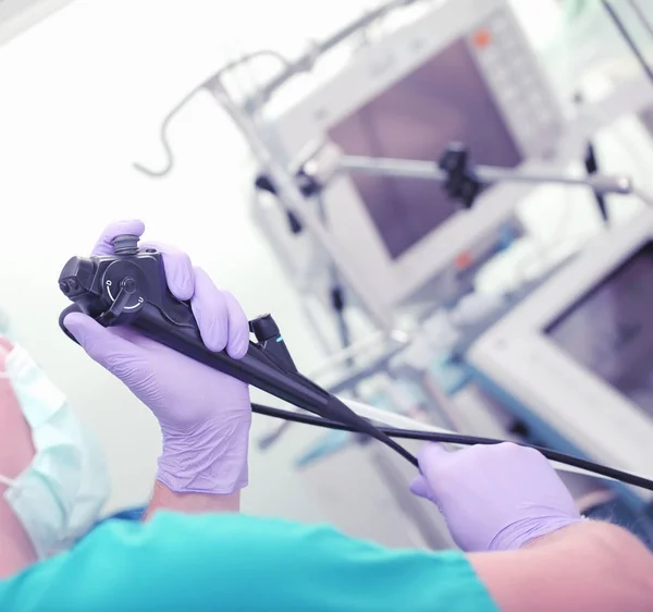 Doctor with endoscopy tool in his hands during procedure — Stock Photo, Image