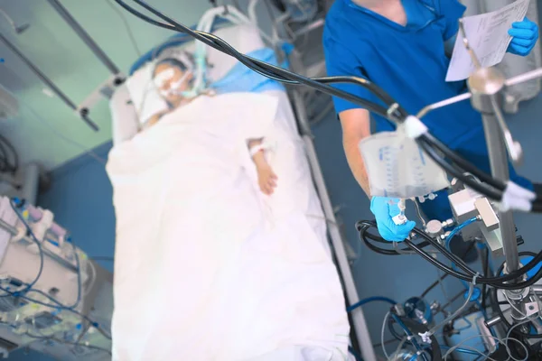 Enfermera masculina que regula el flujo de perfusión intravenosa junto a t — Foto de Stock