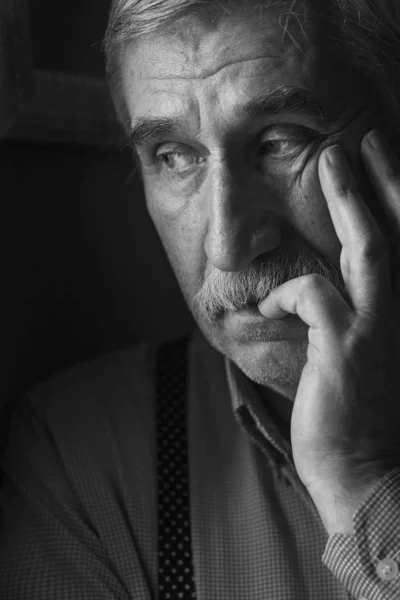 black and white portrait of an elderly man, close-up, print and sadness. Elderly sad man close-up portrait