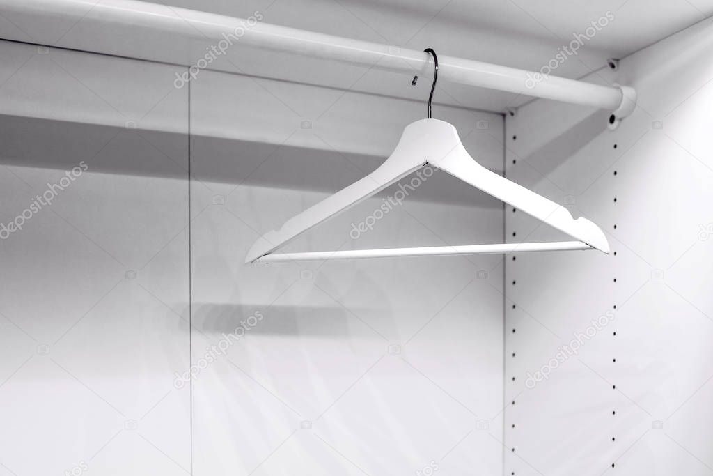 white clothes hanger in a white wardrobe, empty wardrobe, the concept of moving, a change of residence, sales
