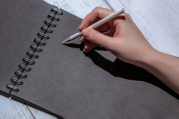Frauenhand Mit Weißem Bleistift Auf Schwarzem Blatt Papier Konzept Für — Stockfoto