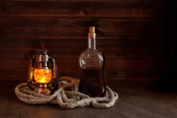 Μπουκάλι Δυνατό Αλκοόλ Ρούμι Ουίσκι Δίπλα Ένα Παλιό Καμμένο Φανάρι — Φωτογραφία Αρχείου