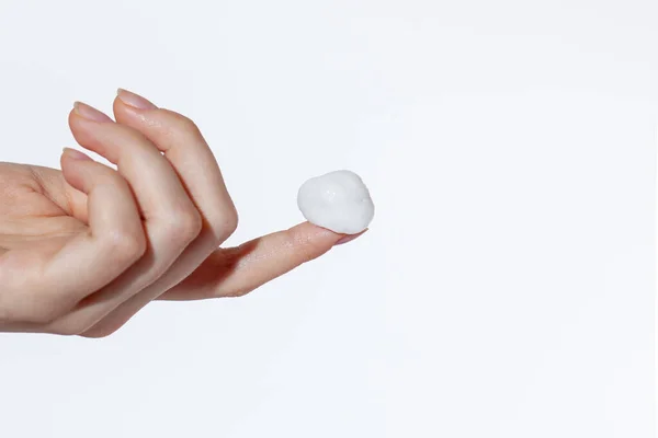 漂亮的女性手食指上的白色泡沫或软糖 白色背景隔离 — 图库照片