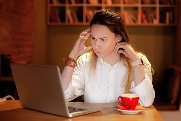 Frustrated woman looking at computer screen, getting bad news, financial problems, tired woman in stress, focused on work