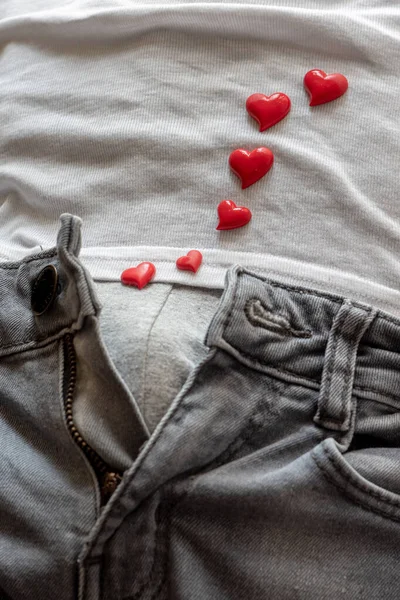 open zipper on men\'s jeans, red hearts around, the concept of love and surprise for Valentine\'s Day